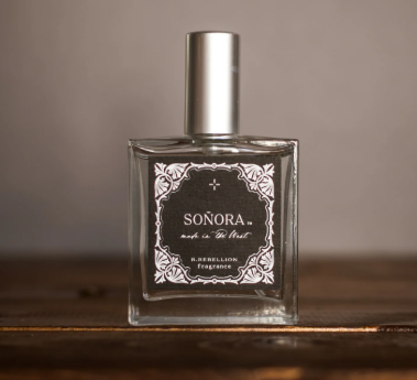 Perfume bottle labeled 'Sonora' on a wooden surface with a neutral background