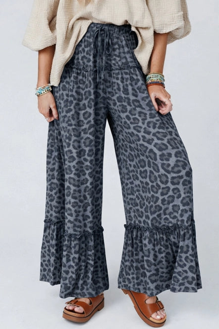 Person wearing leopard print pants with a plain background