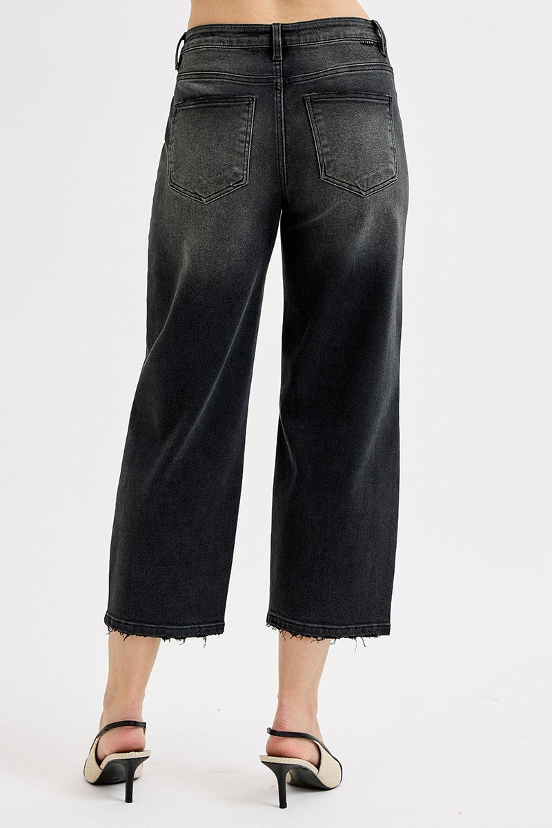Black jeans worn by a person on a white background