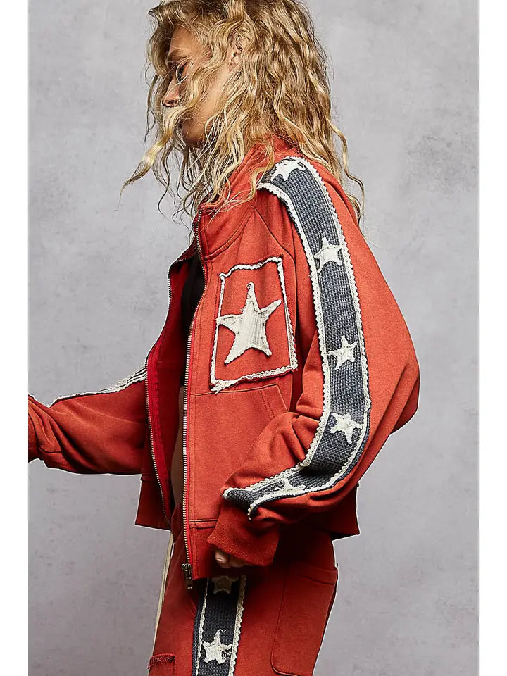 Person wearing a red jacket with star patterns on a gray background