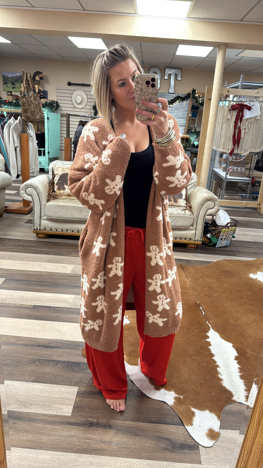 Person wearing a patterned cardigan and red pants in a store setting