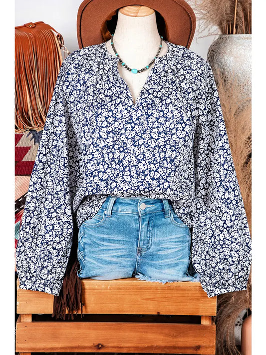 Mannequin wearing a blue floral blouse and denim shorts with a rustic background.