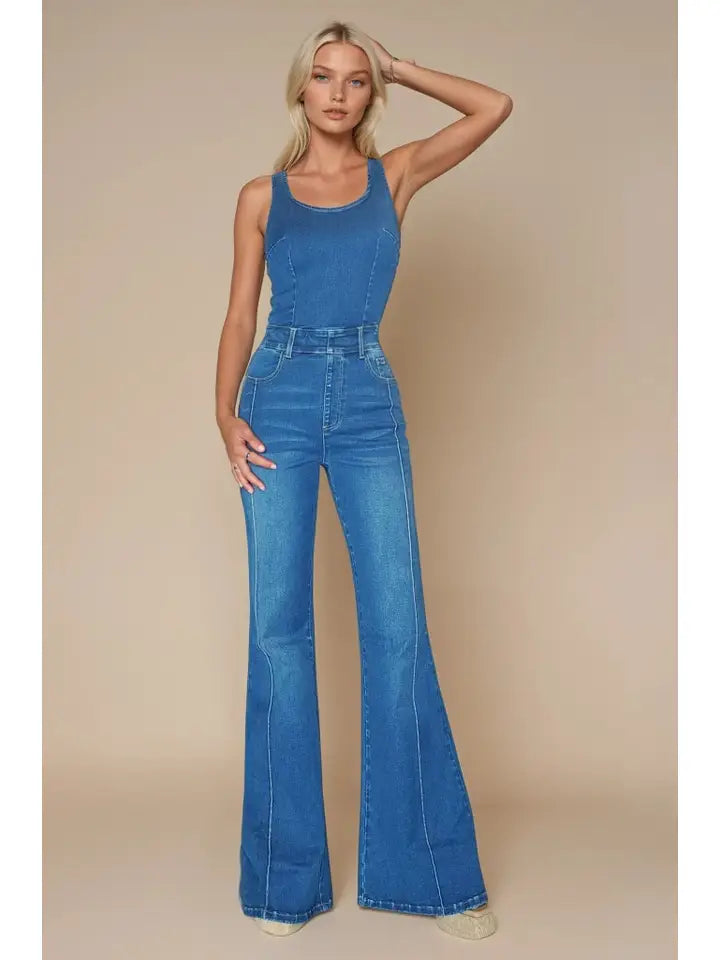 Woman wearing a blue sleeveless denim jumpsuit.